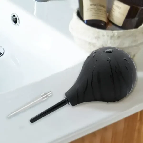 poire à lavement noire posée sur un lavabo